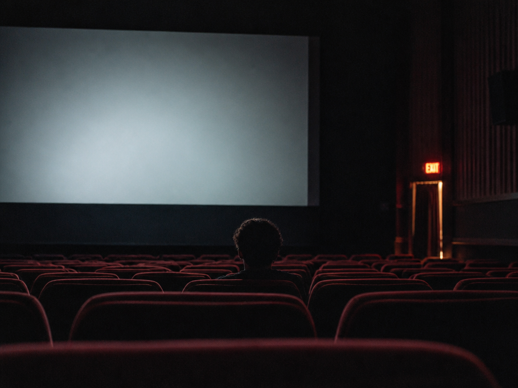 A photorealistic wide interior shot of a near-empty cinema auditorium after a screening, rows…