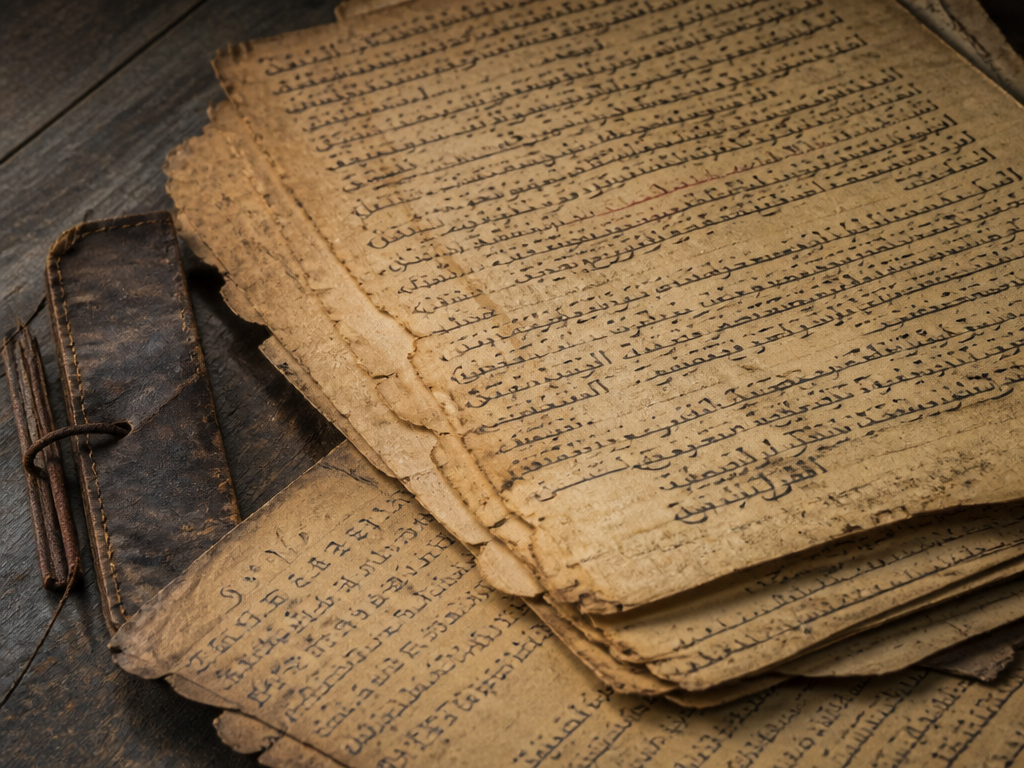 A close overhead still life of aged manuscript pages from a Timbuktu family library…
